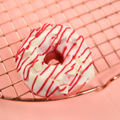 FITbelly donut with white glaze and red drizzle on a pink background
