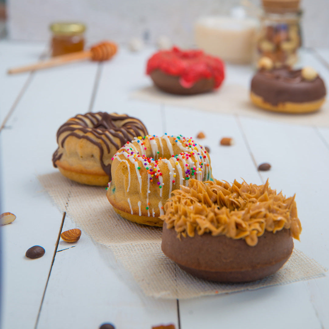 Assorted FITbelly donuts on a white surface with a blurred background